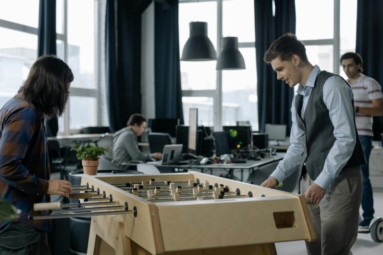 An image of the Appoly office, showing employees playing on the football table.