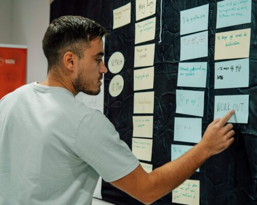 A man pointing at a note that says Workout.